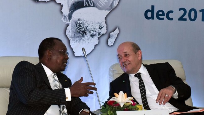French Defence Minister Jean-Yves Le Drian (R) speaks to Chadian President Idriss Deby Itno as they attend the last day of the International Forum on Peace and Security in Africa in Dakar on December 16, 2014. Malian President Ibrahim Boubacar Keita called on the world community to put an end to instability in southern Libya, which he called a "hornet's nest" and a "fabulous market of weapons to our countries." AFP PHOTO / SEYLLOU
